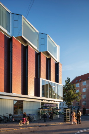 Wohnsporthalle, Dorte Mandrup, Kopenhagen, Neubau, 2015, 2016, Fertigstellung, Sporthalle, Wohngebude, Sandwich, Hybrid, Amagerbrogade, Parmagade, Glas, Holz, Balkone, Terrasse, Stadt, Block, city bloc, wood, terrace, gymnasium, grocery, sportshall, SH2 Sundbyoster Hall, apartments, Gemsehndler