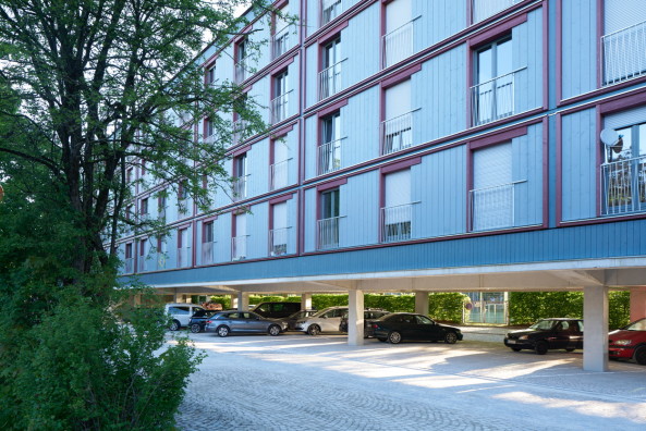 Baunetz, Meldung, Architektur, architecture, Mnchen, Deutschland, Munich, Germany, Florian Nagler, Stelzenhaus, Dantebad, Wohnen, Parkplatz, Parkplatzberbauung, Sttzen, Sulen, columns, parking, residential, carpark, GEWOFAG, Stefan Mller-Naumann, sozialer Wohnungsbau, Geflchtete, Flchtlinge, Migranten, refugees, Laubengang, Laubenganghaus, Holz, wood, Vorfertigung, Standardisierung, Farbe, colour, prefabrication, piloti