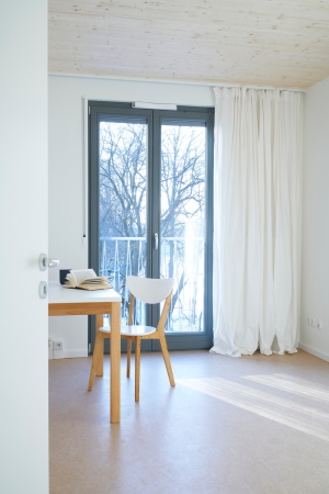 Baunetz, Meldung, Architektur, architecture, Mnchen, Deutschland, Munich, Germany, Florian Nagler, Stelzenhaus, Dantebad, Wohnen, Parkplatz, Parkplatzberbauung, Sttzen, Sulen, columns, parking, residential, carpark, GEWOFAG, Stefan Mller-Naumann, sozialer Wohnungsbau, Geflchtete, Flchtlinge, Migranten, refugees, Laubengang, Laubenganghaus, Holz, wood, Vorfertigung, Standardisierung, Farbe, colour, prefabrication, piloti