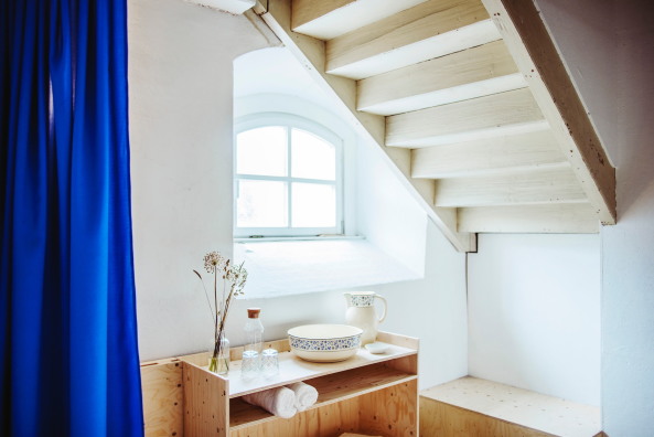 Ein Waschtisch erweitert das Schlafzimmer, das Proportionen und Elemente des Kirchenschiffes aufgreift.