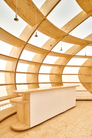 Die Holzkonstruktion spannt den Raum auf und kann als Buchregal genutzt werden.