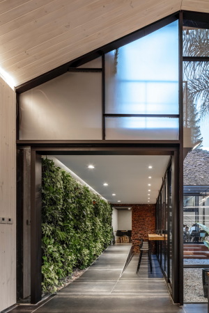 Ein glserner Korridor mit grner Wand verbindet die beiden Hauptrume miteinander