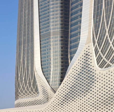 Die Fassade des unteren Gebudesegments der Trme bespielen Zaha Hadid Architects mit Paneelen aus Textilbeton, die sie wie ein Gitter ber den Bau spannen.