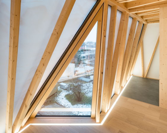 Die leichte, transluzente Fassade ist mit Fenstern durchsetzt und lässt natürliches Tageslicht in die Wohnräume.