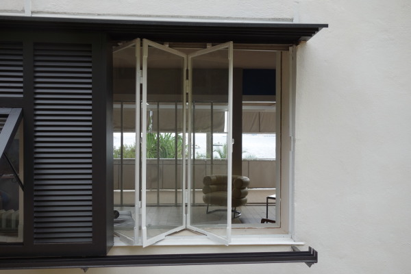 E.1027, Blick durch das Falt-Schiebefenster in den Salon. Auf der anderen Seite ist schon der Sdbalkon und ein Blick aufs Meer zu sehen.