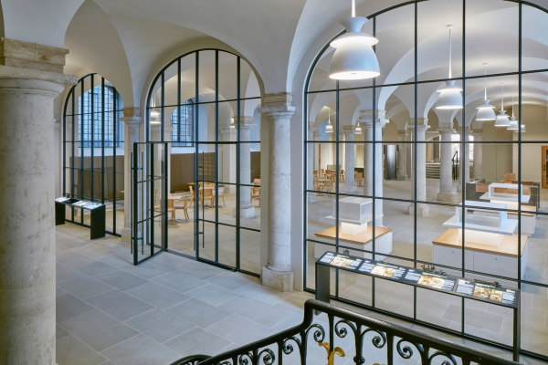 Hugh Broughton Architects integrierten drei schlichte Glasbogen mit Metallrahmung.