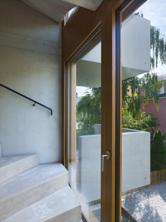 Die enge Treppenanlage in rohem Beton ist dank bodentiefer Fenster mehr als nur ein funktionales Element.