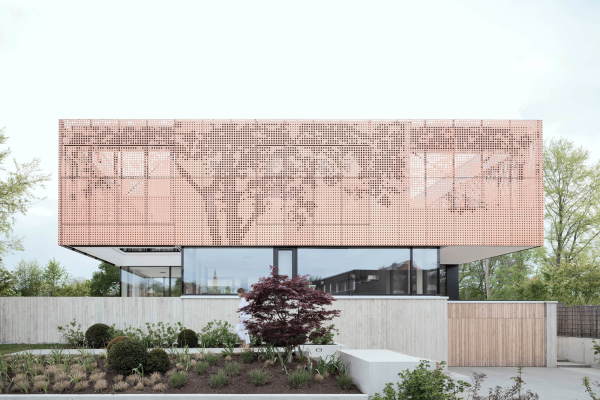 Im geschlossenen Zustand wirkt die Fassade aus Kupferblech mit dem abstrahierten Baummotiv hermetisch.
