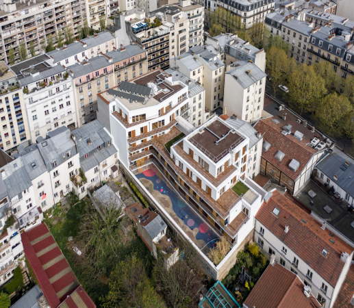 Ein langgestrecktes Gebudevolumen fgt sich in der dichten Bebauung der Pariser Nachbarschaft ein.