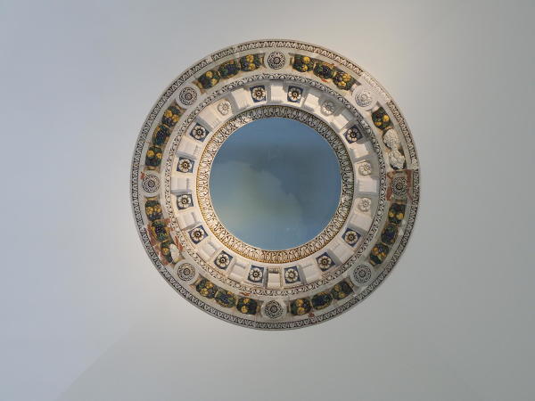 Der historisch erhaltene und aufwendig restaurierte Schmuckring aus Majoliken rahmt das Oberlicht.