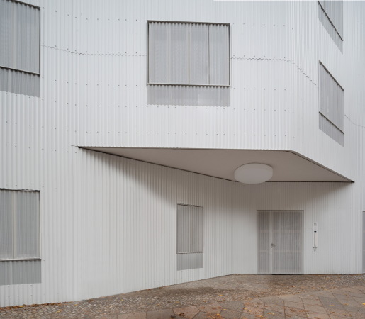 Die Aluminium-Wellblech-Verkleidung spannten rundzwei Architekten ber die komplette Straenfassade.