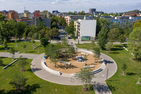 Ein Tisch umringt von Sitzgelegenheiten symbolisiert das Zusammenwachsen der Kieze.