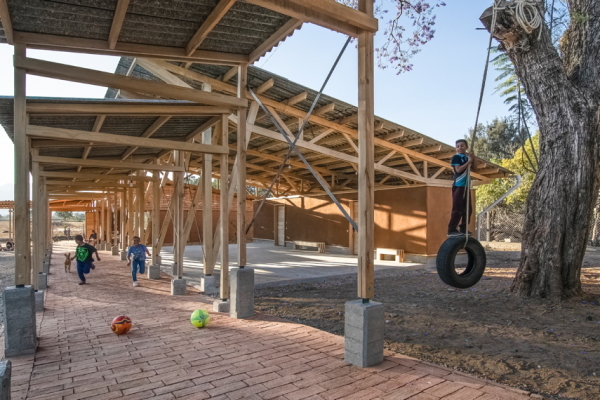 Eine Galerie dient als Verbindungsgang, bietet Platz im Schatten und Schutz vor Regen.