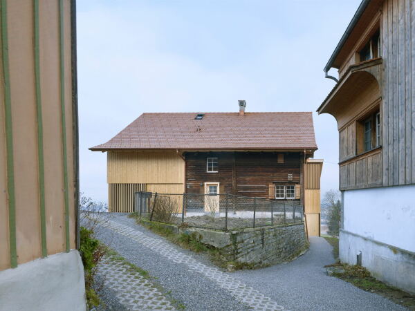 Blick von Süden auf das Haus am Buechberg in Thal (St. Gallen): Die Tür in der Mitte ist der Zugang zur größeren Wohneinheit; der Weg rechts führt in die kleinere.