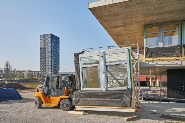 Die vorfabrizierten Fassadenelemente wurden mit dem Gabelstapler auf die unterste Plattform des NEST gehoben