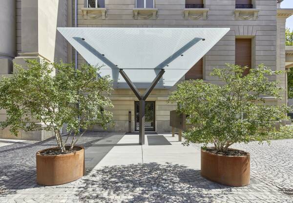 Weit auskragendes Vordach als minimalistische Glas-Stahlkonstruktion im Kontrast zum prunkvollen Eingang in die Beletage