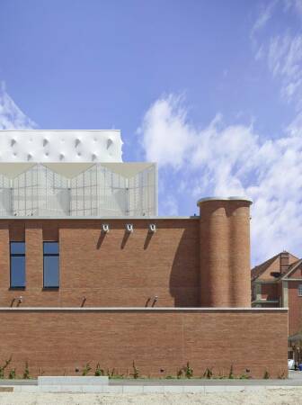 Hhenstaffelung nach Funktionsbereichen: Sichtziegelmauerwerk fr den Theaterbau, gefaltete Metallgitterkonstruktion als Hlle der gebudetechnischen Anlagen, der 30 m hohe Bhnenturm aus Stahlbeton mit weithin sichtbarer, semitransparenter Membran