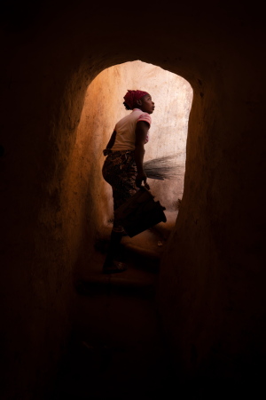 Eine Frau steigt in Bobo-Dioulasso auf das flache Dach eines Gebudes.