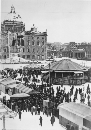 Der erste Nachkriegs-Weihnachtsmarkt am Lustgarten mit Blick auf das beschdigte Schloss, Dezember 1945