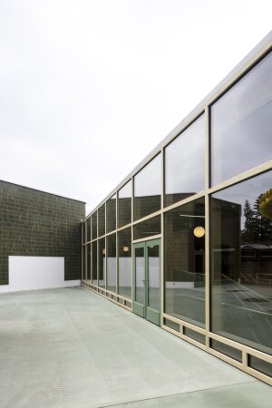 Der Neubauriegel trifft mit seiner Glasfassade auf den Multifunktionsraum