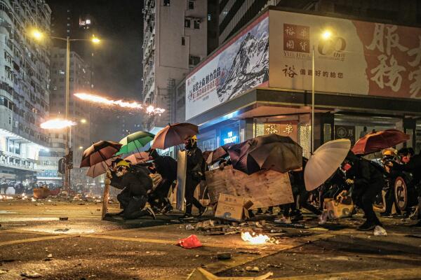 20192020, Hongkong: Protestierende mit Schutzausrstung und Regenschirmen im Straenkampf