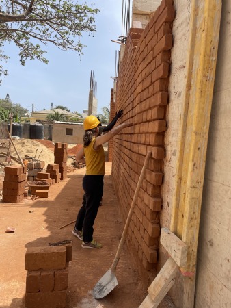 Die Betonelemente werden mit geschnittenen Steinen verkleidet.