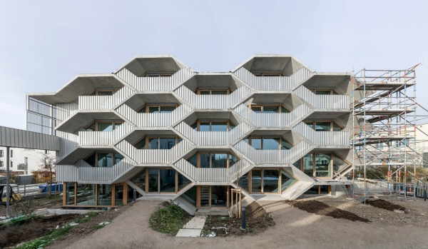 Das Fassadenbild ergnzen perforierte Metallpaneele an den Balkonen, als Verkleidung der Sdseite sowie am Gartenhaus, dort wiederum gepaart mit einer vertikalen Holzlattung.