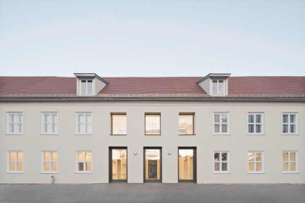 Der ehemalige Weg in die Gartenstadt bildet sich in der grozgigen Fassadenffnung ab.